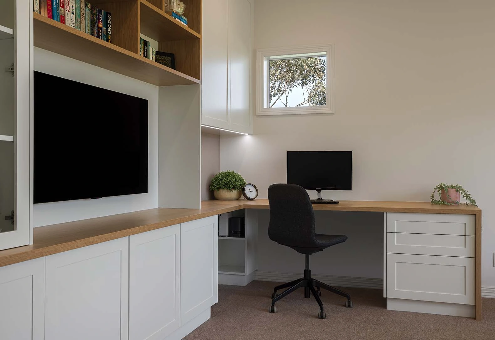 Stylish home office with a desk, ergonomic chair, and a TV